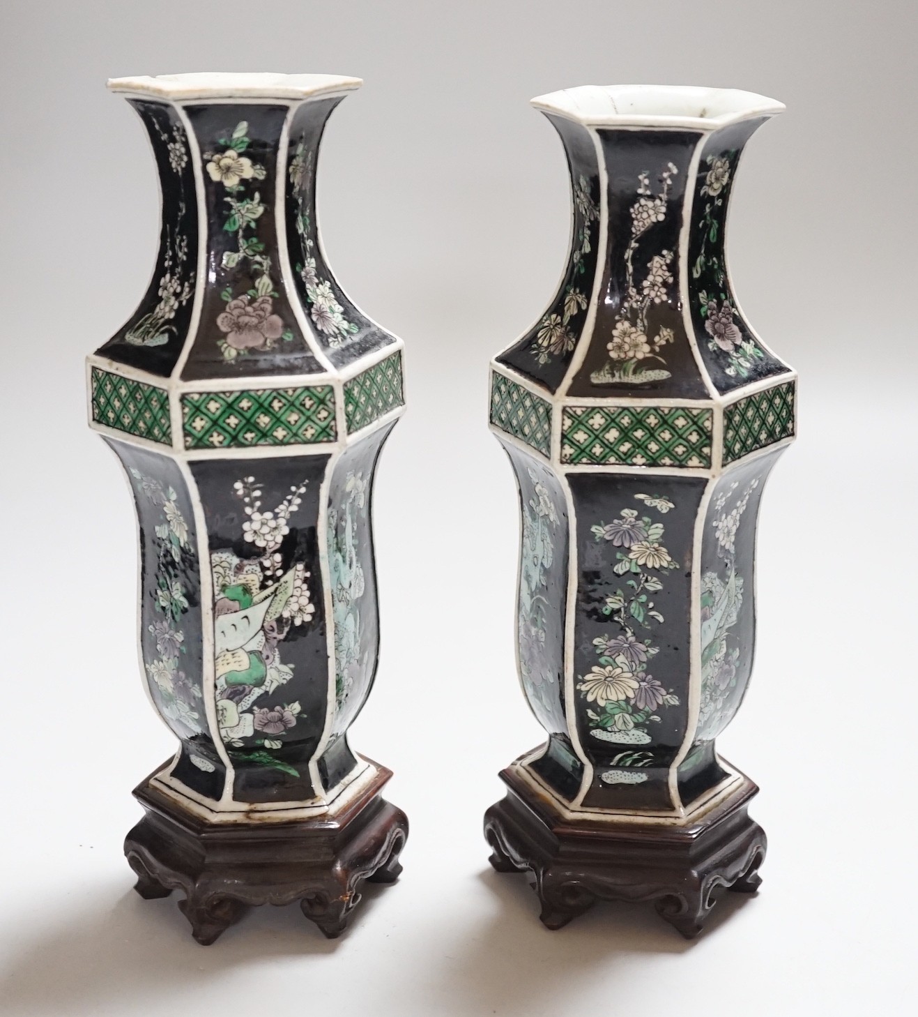 A pair of Chinese famille noire hexagonal vases, late 19th century, wood stands, 21cms high including stands